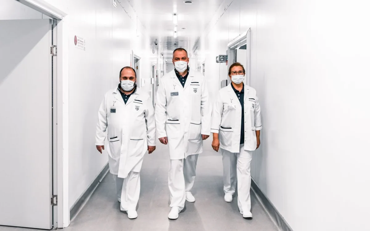 Trei cadre medicale merg pe un coridor de spital