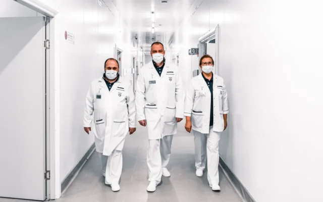 Trei cadre medicale merg pe un coridor de spital