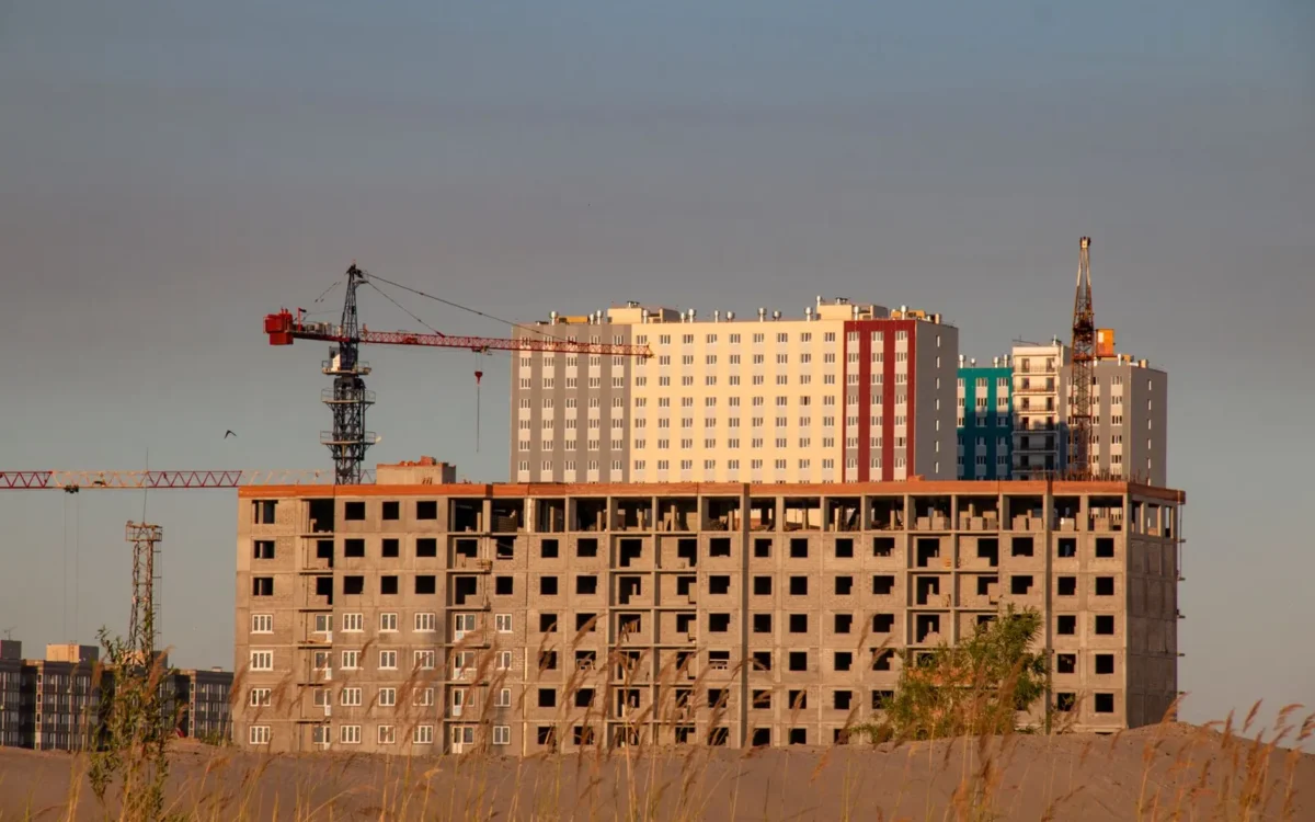 Clădire cu mai multe etaje în construcție, lângă macarale