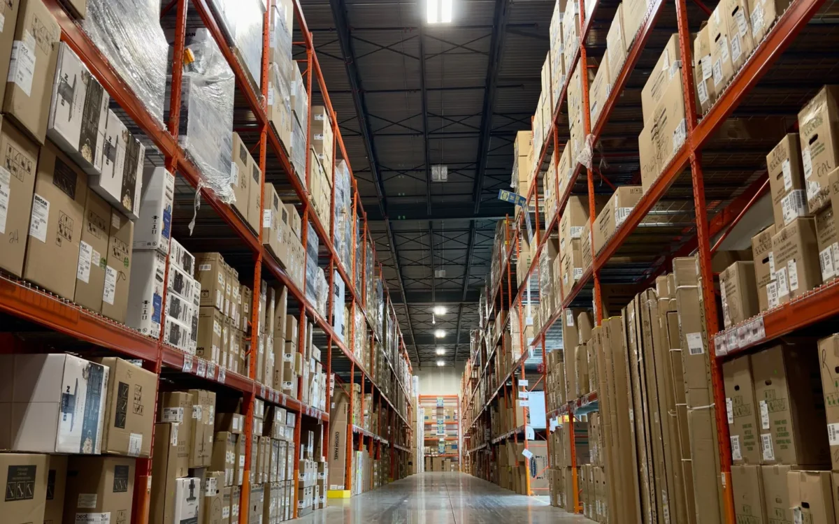Culoar de depozit cu rafturi înalte pline cu produse