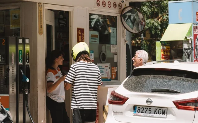 Autoturisme și persoane la o stație de alimentare