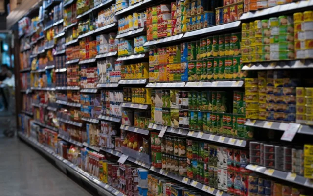 Rafturi cu conserve și alimente ambalate într-un magazin