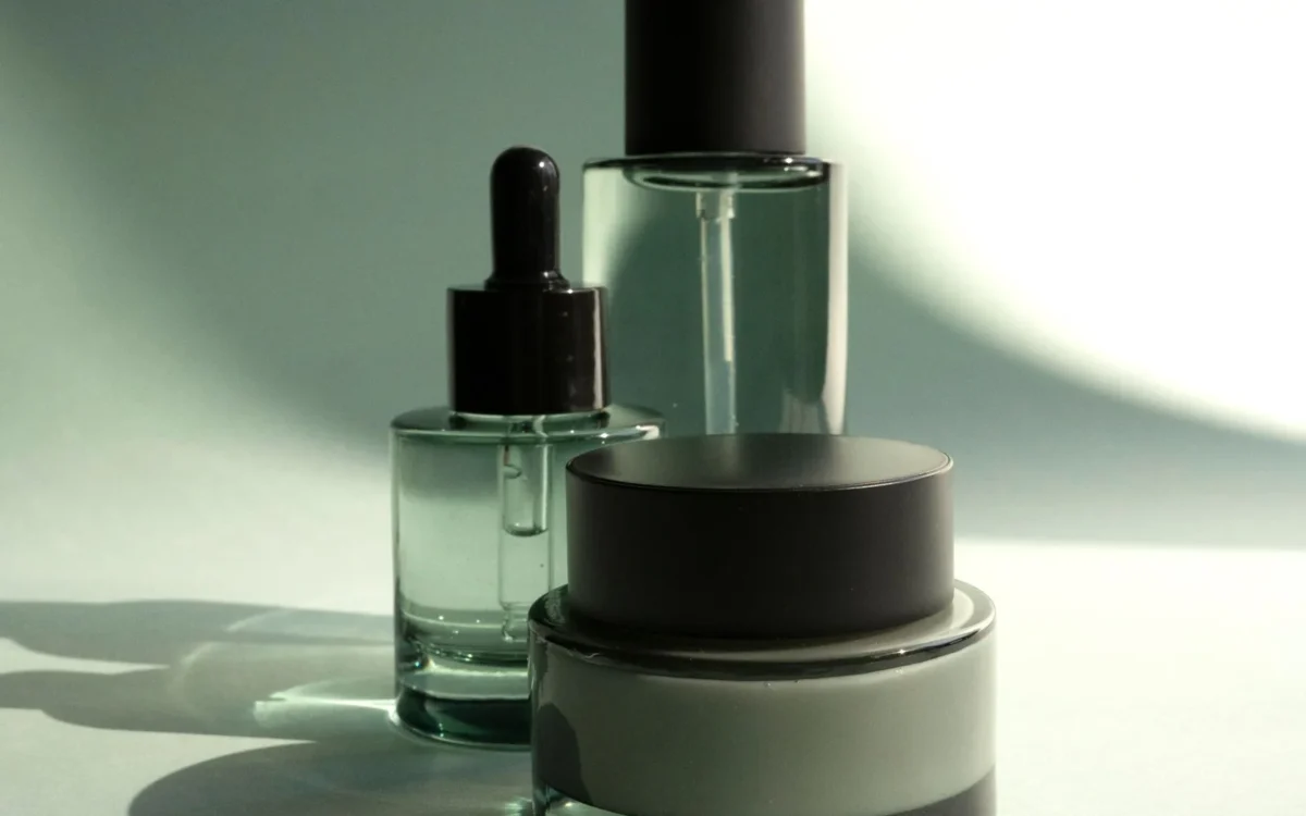Flacoane cosmetice și recipient cu cremă, cu capace negre