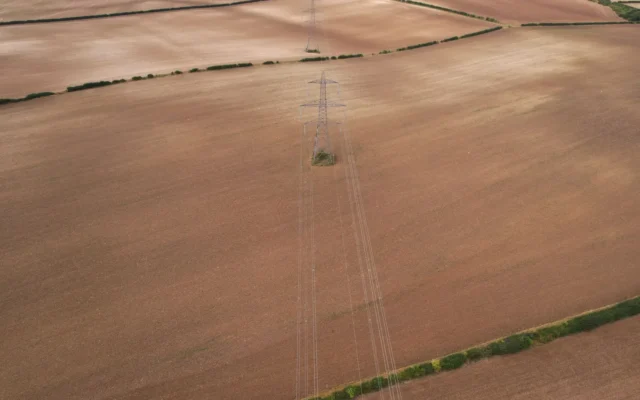Linii de înaltă tensiune traversând câmpuri agricole