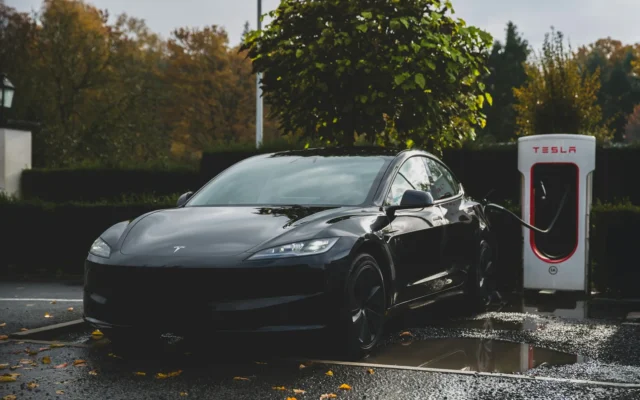 Tesla Model 3 gri conectat la o stație de încărcare